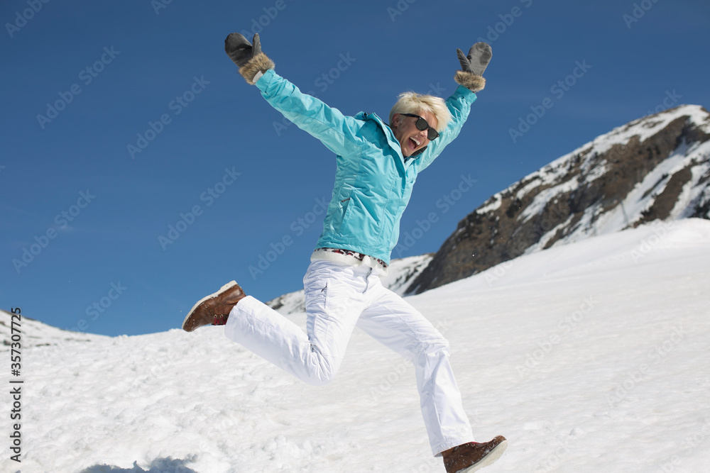 Exuberant woman playing in snow