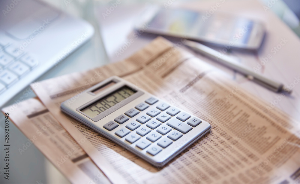 Calculator,close up,newspaper and pen on desk Calculator,close up,newspaper and pen on desk