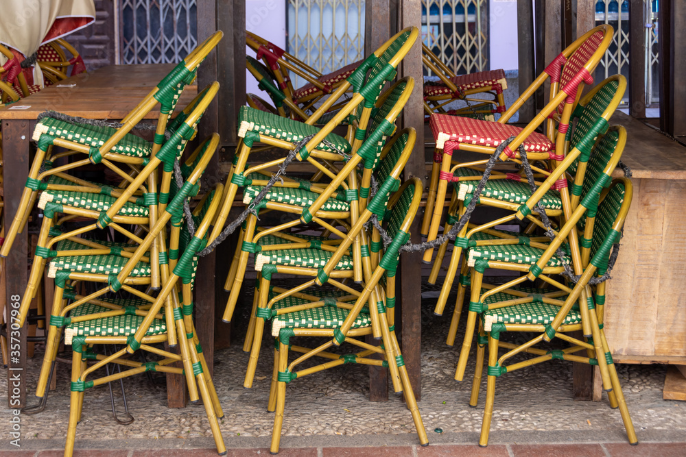 Green and red chairs stacked on the terrace of a closed bar due to lack of customers due to the pandemic