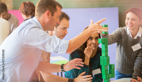 Business people stacking green blocks