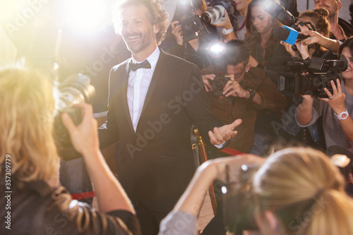 Smiling celebrity posing for paparazzi photographers at event