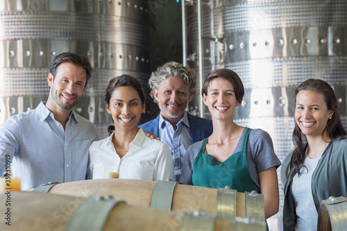 Portrait confident winery employees in cellar