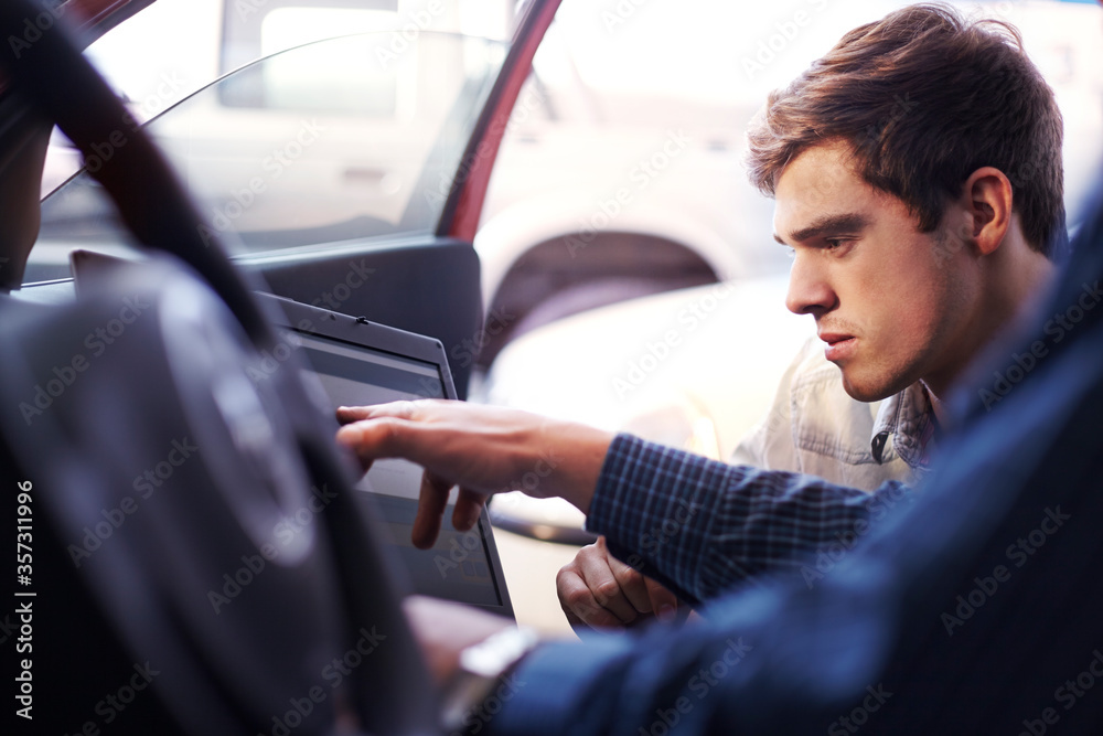 Mechanic and customer with laptop inside car Mechanic and customer with laptop inside car