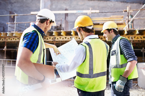 Fotografija Construction workers engineer reviewing blueprints at construction site
