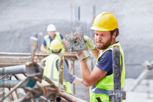 Construction worker carrying metal bar at construction site photo