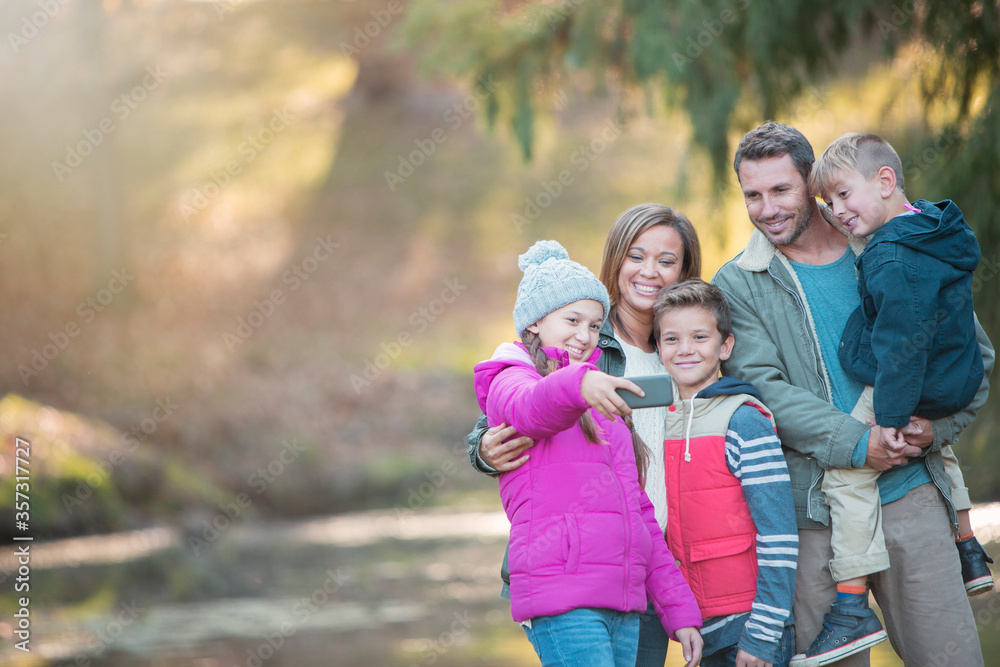 Family taking selfie with camera phone in woods Family taking selfie with camera phone in woods