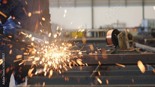 Electric wheel grinding on steel structure in factory
