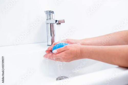 Hand washing with human soap and water to prevent coronavirus viruses, hygiene to stop the spread of coronavirus. Woman uses soap and washes her hands under the tap. Hand hygiene concept detail.