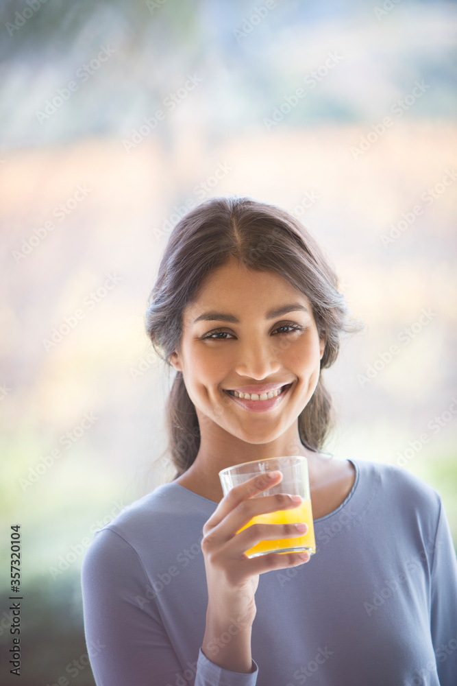 Portrait smiling woman drinking orange juice