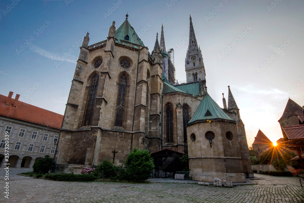 Zagreb Cathedral Croatia with cobblestone walkway and sun flare off to the side