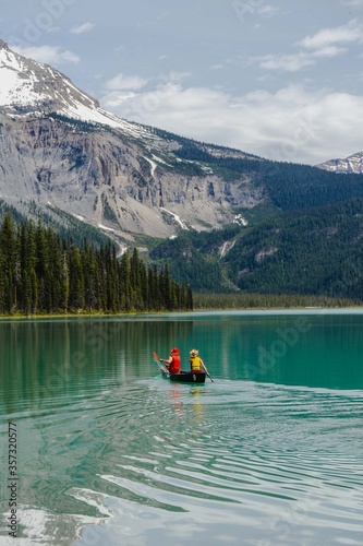 Iconic wooden lodge, red kayaks, people kayaking on breathtaking Emerald Lake, Yoho National Park, Beautiful British Columbia, Canada