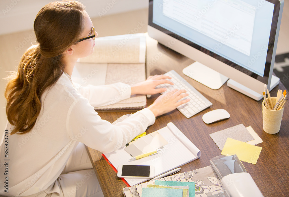 Interior designer working at computer in home office Interior designer working at computer in home office