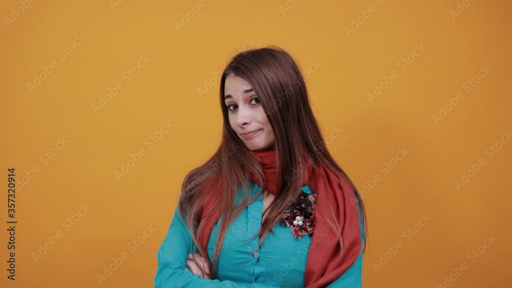Standing and cross arms on chest. Young attractive woman with brown hair, eyes, decoration on blue shirt, yellow background. Young attractive woman with brown hair, eyes, decoration on blue shirt Standing and cross arms on chest. Young attractive woman with brown hair, eyes, decoration on blue shirt, yellow background. Young attractive woman with brown hair, eyes, decoration on blue shirt