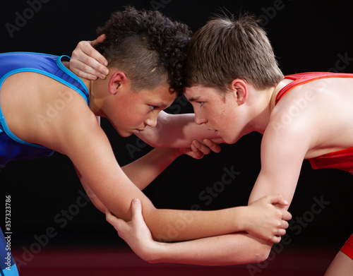 Photography Wrestlers in red and blue singlets practicing on a red mat.