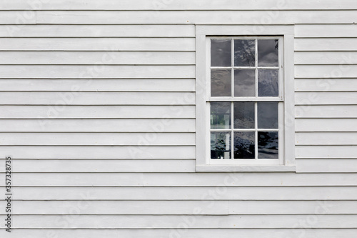 Old Single Pane Window in an Exterior Wall with White Siding