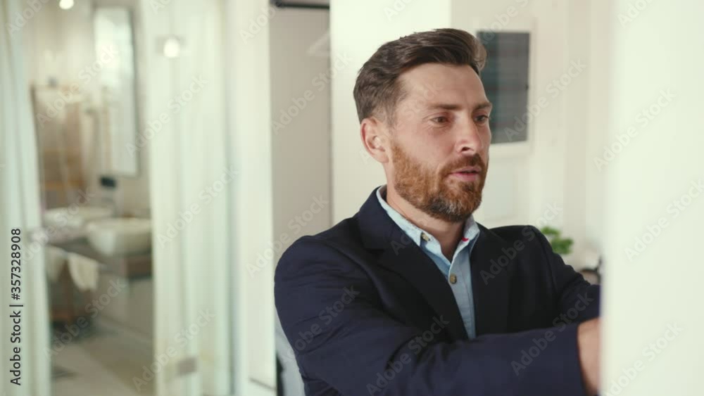 Attractive businessman getting ready with mask look at mirror and wearing suit jacket go work home safety professional protection apartment corona pandemic slow motion Attractive businessman getting ready with mask look at mirror and wearing suit jacket go work home safety professional protection apartment corona pandemic slow motion