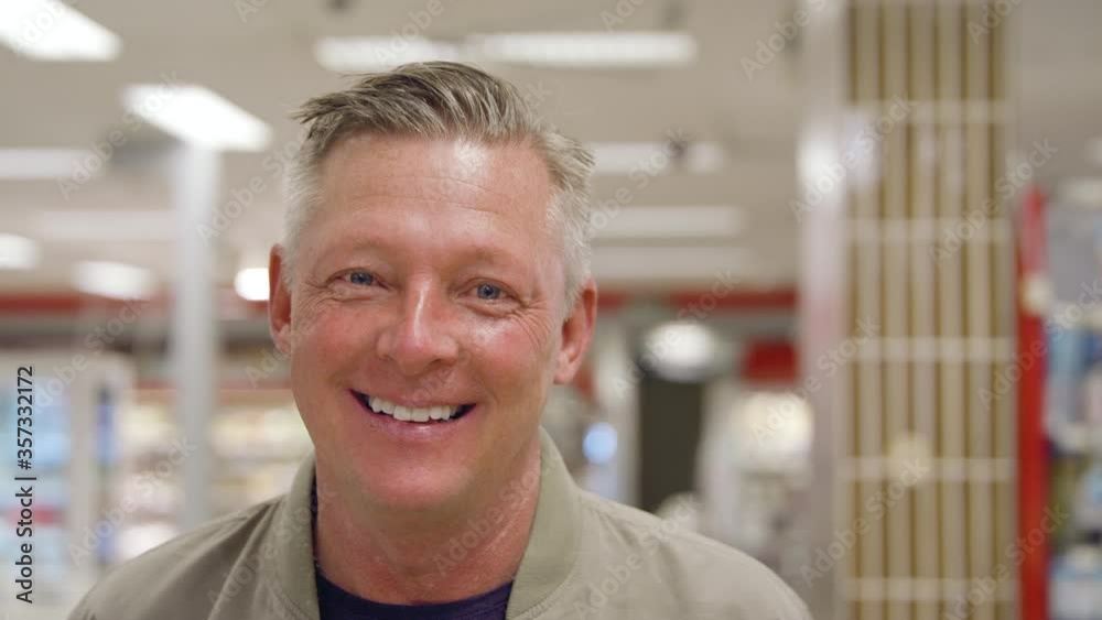 Portrait of a happy middle-aged man in grocery store.