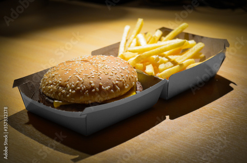 A fast-food restaurant hamburger (cheeseburger) with fries