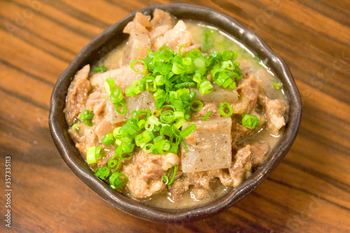 鮮やかな緑色のネギの小口切りをたっぷり天盛りにした牛すじとこんにゃくの味噌煮込み、大阪名物どて煮。Osaka specialty Gyusuji Nikomi (Beef Tendons Simmered in miso)  ,Stewed Beef Tendons.
