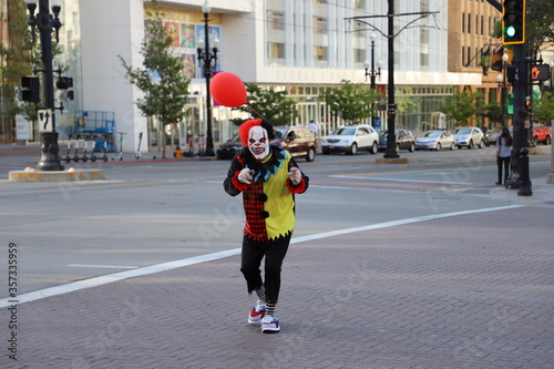 Clown Carrying a Red Balloon on a City Street