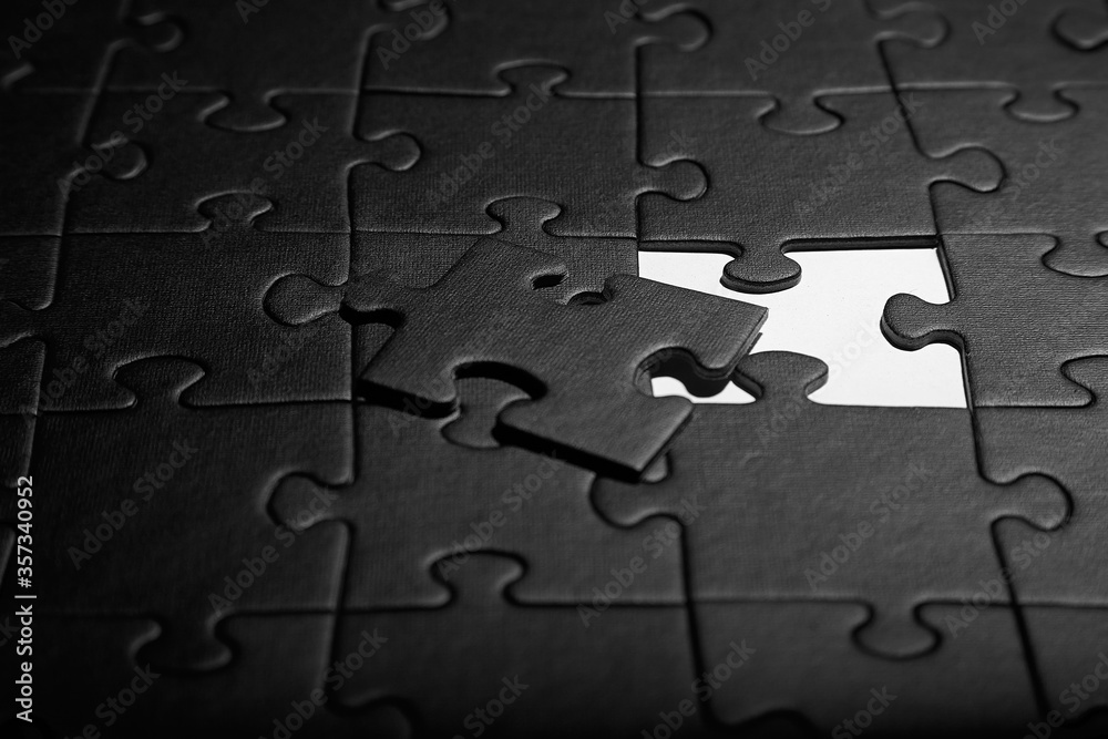 Puzzles in black. Monochrome cardboard shapes. Dark background. Puzzles in black. Monochrome cardboard shapes. Dark background.