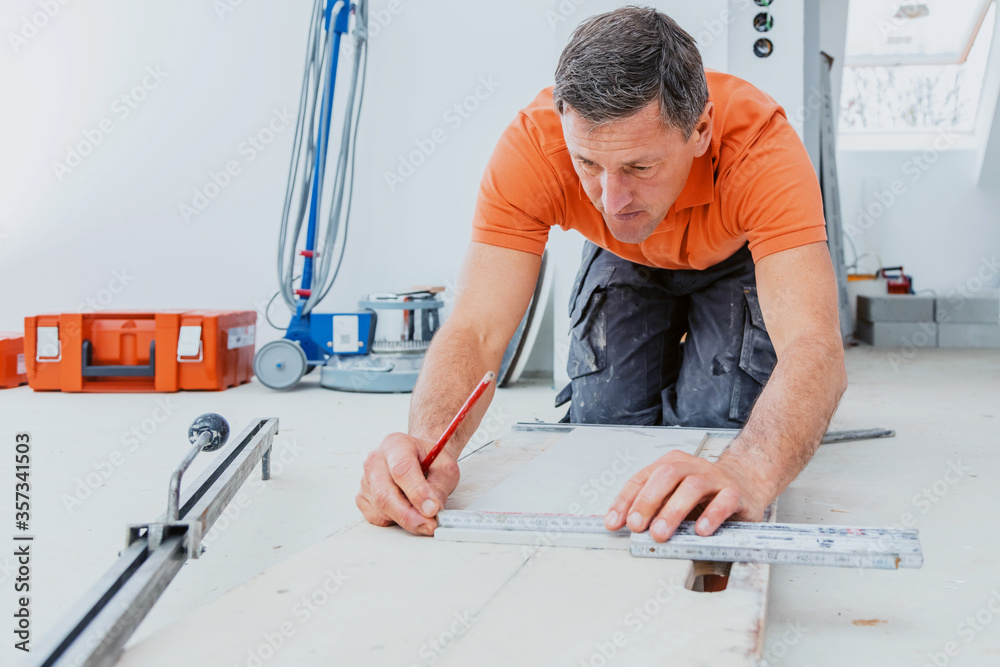 The tiler works in the bathroom of a modern house. The tiler works in the bathroom of a modern house.