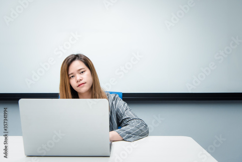 Woman working by laptop in office with happy