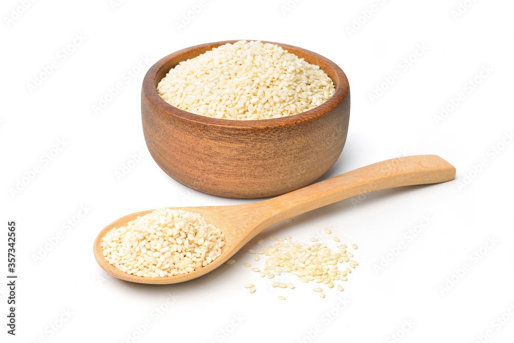 White sesame seeds in wooden bowl and wooden spoon isolated on white background. White sesame seeds in wooden bowl and wooden spoon isolated on white background.