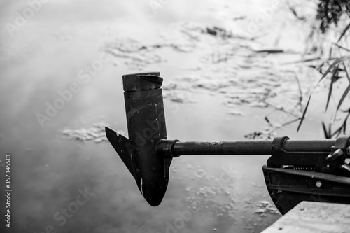 Bilde på lerret Boat trolling outboard motor extended over mossy water