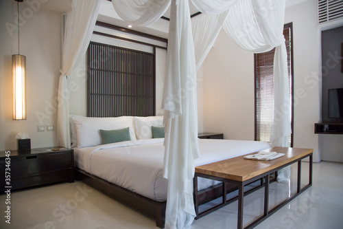 Simple contemporary bedroom with king size bed and mosquito net photo