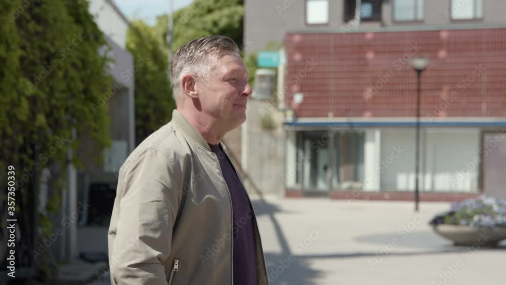 A middle-aged handsome man talking on a square. A middle-aged handsome man talking on a square.