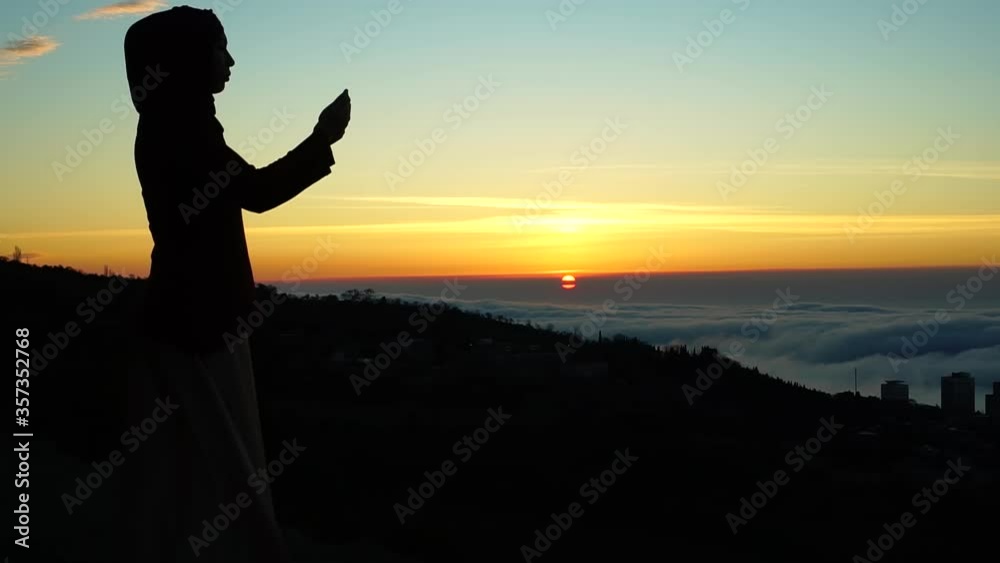 Muslim woman prays. Silhouette at dawn. Islam Religion Muslim woman prays. Silhouette at dawn. Islam Religion