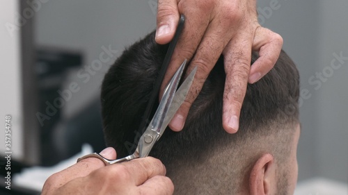 Professional female hairstylist combing and cutting man hair. Close up, slow motion