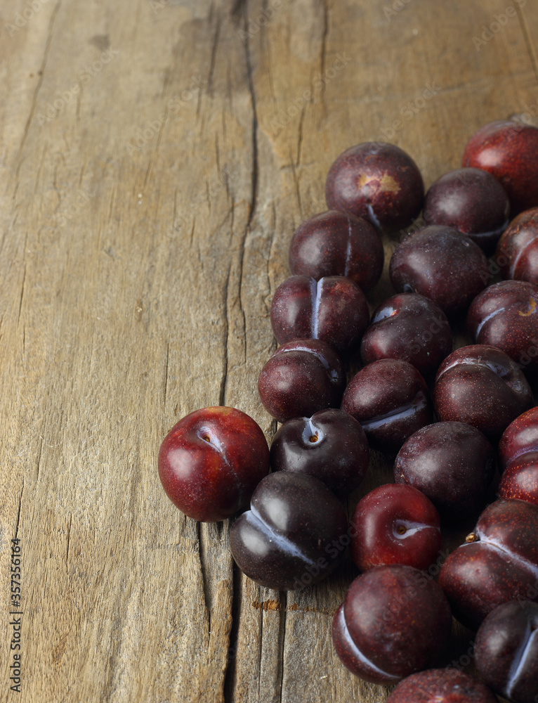 Organic fruits - group of plum lay on wooden table