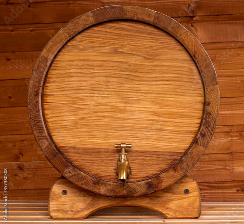 wooden oaken barrel for cellar on a ginger wood backgroung , beer kask with copyspace close up , vine vat of oak