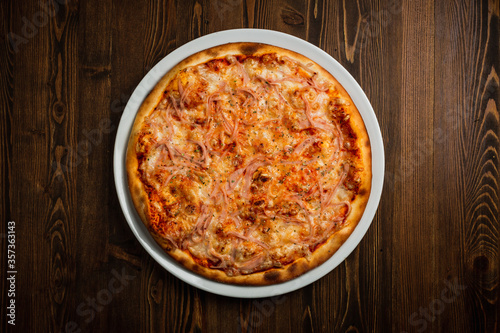 Ham and cheese pizza, wooden background, low key top view