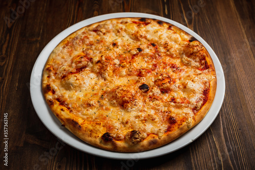 Cheese pizza with a nice crust, wooden background, low key