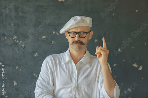 Portrait of a brutal mustachioed cook, in the profession uniform, white cap. glasses man