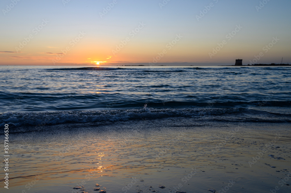 tramonto sul mare con riflesso del sole sull'acqua.