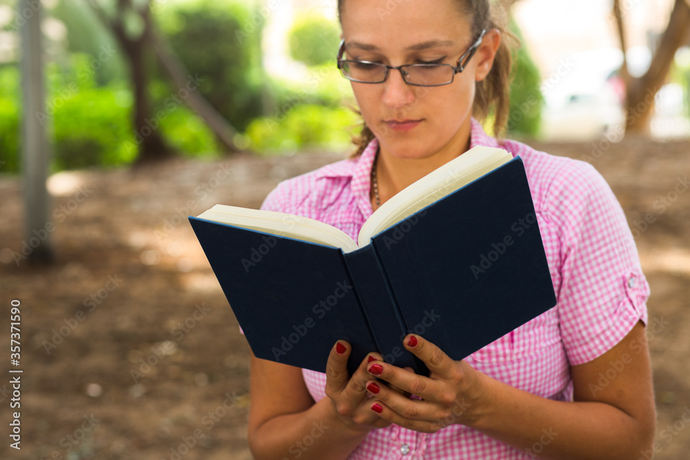 Fototapeta premium Woman reading a book outside.