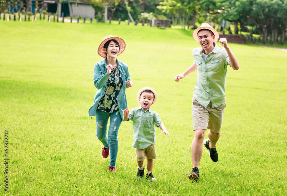 Happy family running together on the grass Happy family running together on the grass