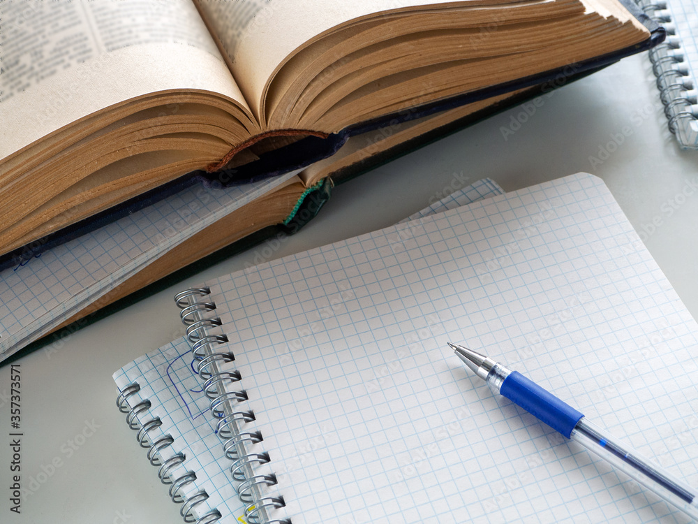Opened books and notebooks are on the table. A pen lies on a blank sheet of  a notebook. Background for education, scientific work, libraries. Stock  Photo | Adobe Stock