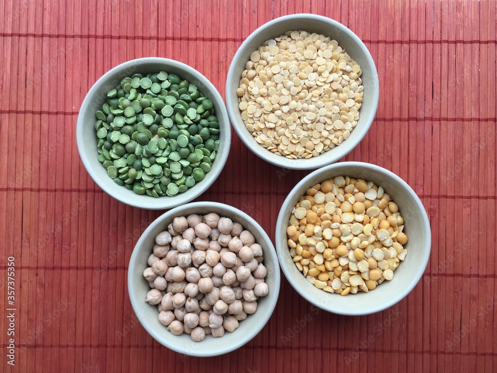 Round bowls with legumes, peas, chickpeas and lentils on a red background. A bowl of food on a plate. High quality photo Round bowls with legumes, peas, chickpeas and lentils on a red background. A bowl of food on a plate. High quality photo