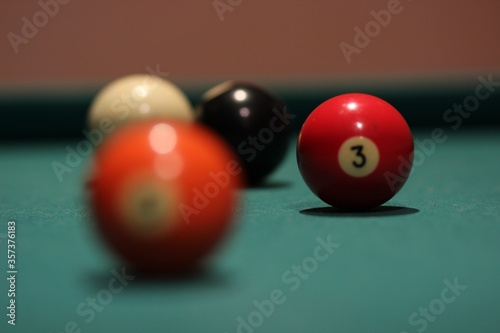 Selective focus shpt of a red billiard ball with the number three photo
