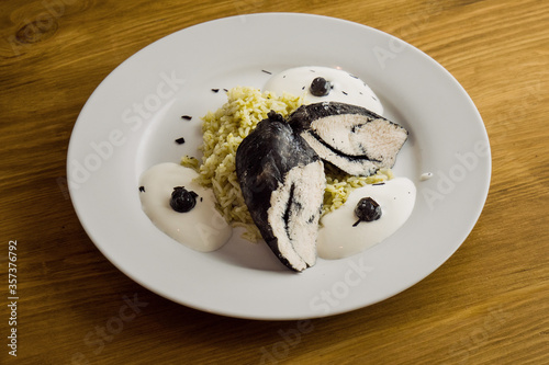 Boiled white rice and chicken fillet colored black with cuttlefish ink.