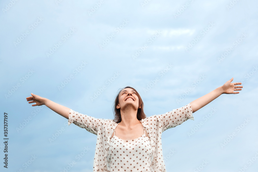 Happy young girl spread her arms and looks to the sky Happy young girl spread her arms and looks to the sky