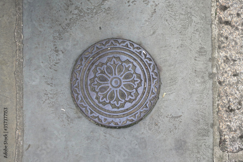 round manhole cover decorated with circles and a floral pattern 2