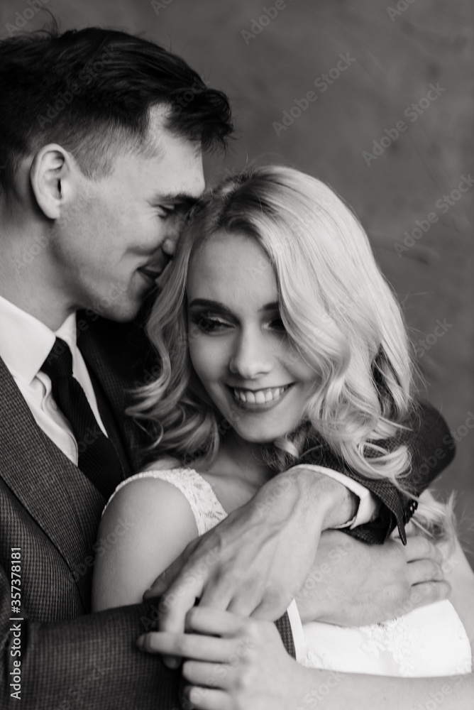 Cute wedding couple in the interior of a classic studio decorated. They kiss and hug each other. Cute wedding couple in the interior of a classic studio decorated. They kiss and hug each other.