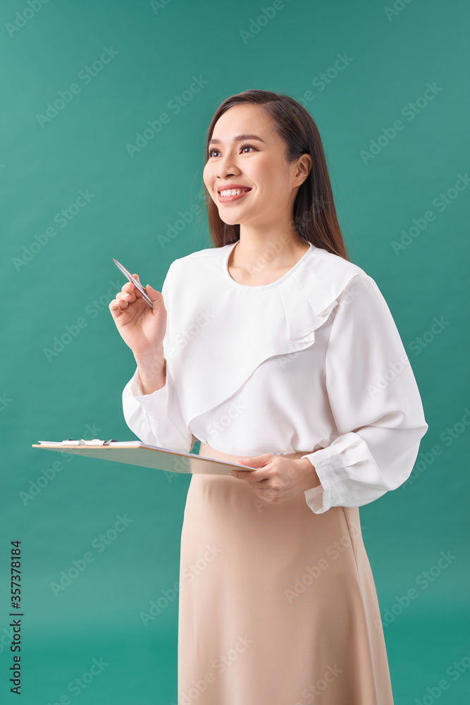 Young Asian business woman holding a paper isolated on turquoise Young Asian business woman holding a paper isolated on turquoise