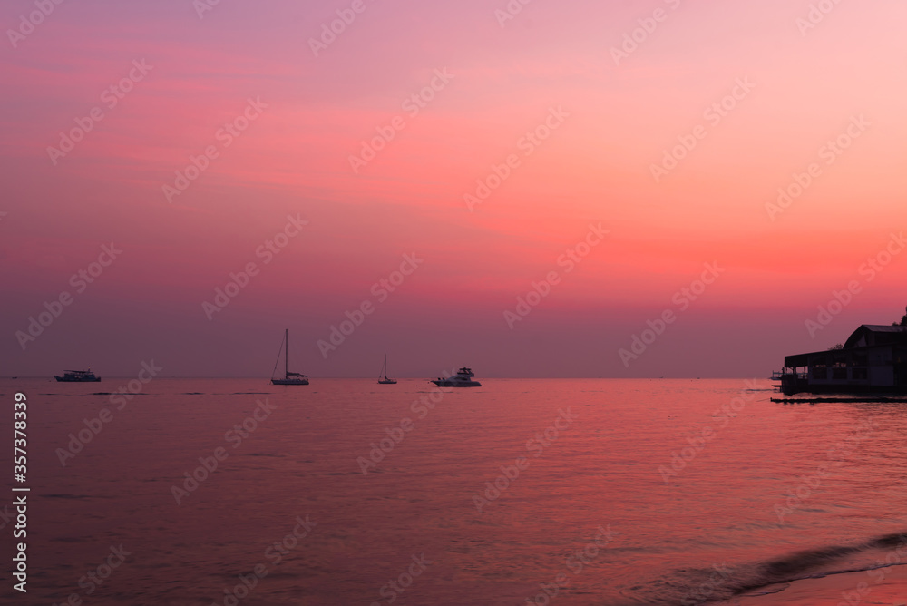 silhouette of fishing boats on lake at sunset